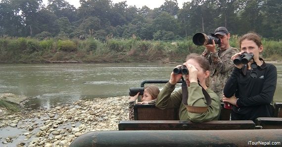 Family with kids watching wildlife in Chitwan National park.